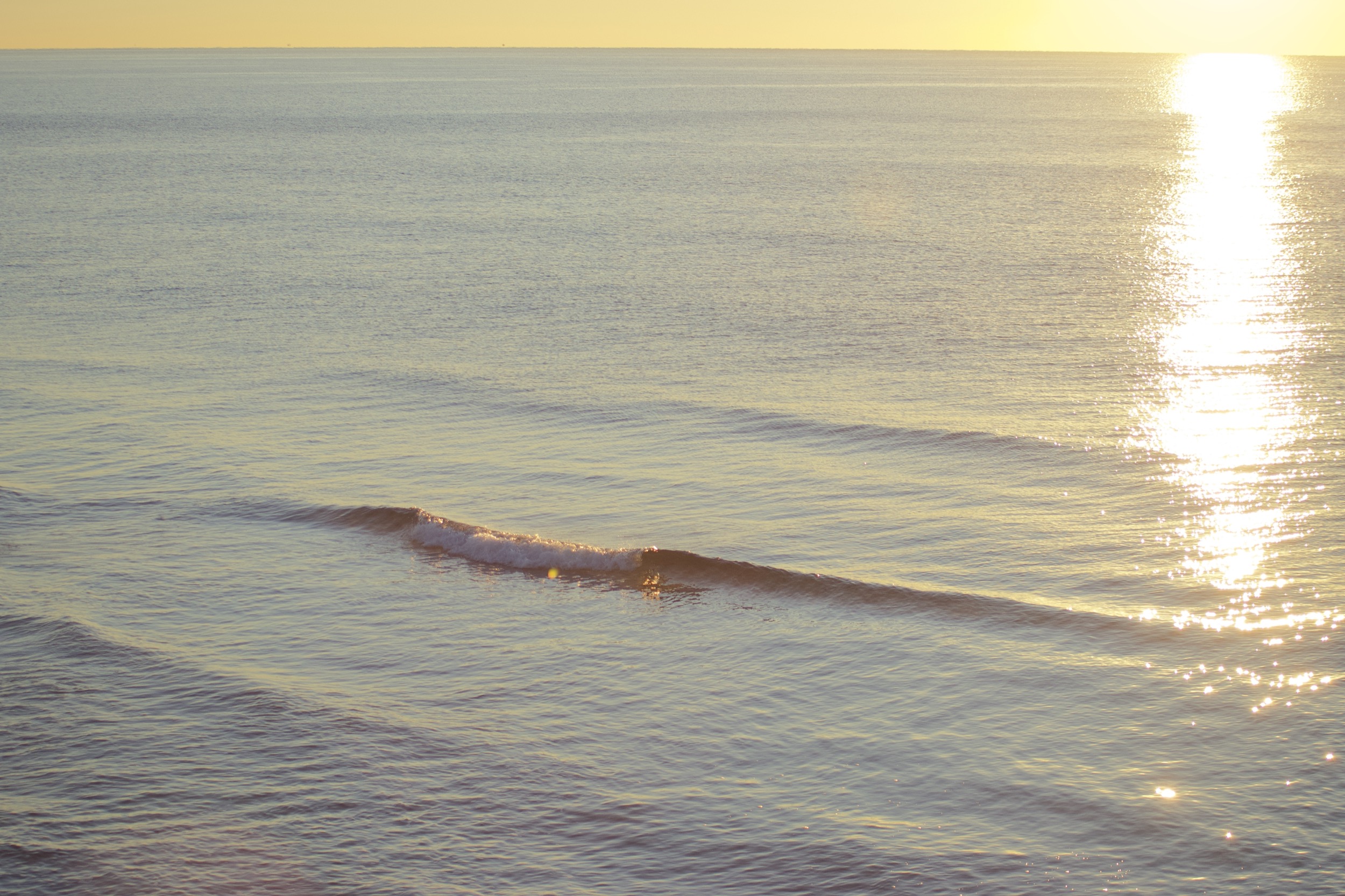 just a ripple, a small wave under the sunrise sky