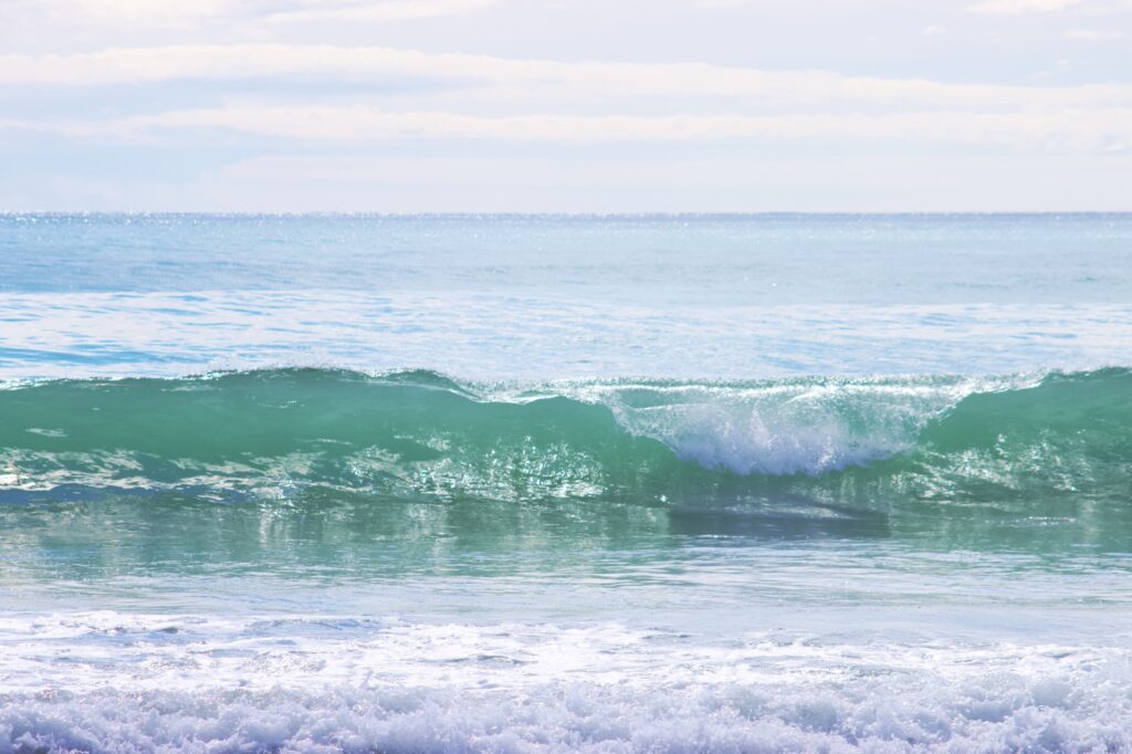 green wave starting to break with beautiful reflections